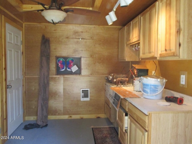 kitchen with light countertops, light brown cabinets, and wood walls