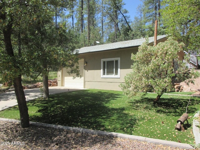 view of property exterior featuring a garage, a lawn, and concrete driveway