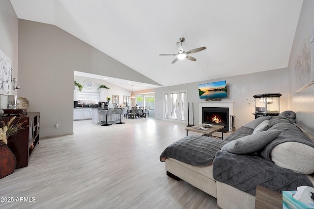 11446 N 109th St, Scottsdale, AZ 85259 - living room featuring a ceiling fan, a lit fireplace, light wood finished floors, and high vaulted ceiling