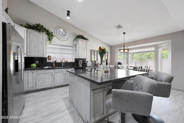 11446 N 109th St, Scottsdale, AZ 85259 - kitchen featuring stainless steel fridge with ice dispenser, a kitchen breakfast bar, a kitchen island, a chandelier, and hanging light fixtures
