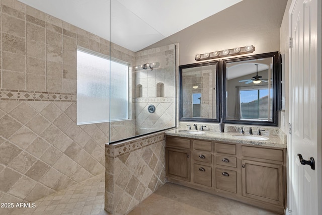 bathroom featuring tiled shower, tile patterned floors, vaulted ceiling, and vanity