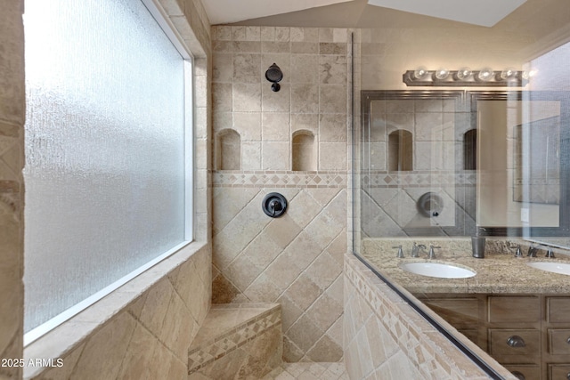 bathroom featuring vanity, lofted ceiling, and a tile shower