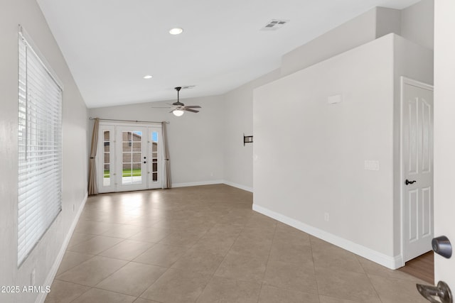 spare room featuring vaulted ceiling, light tile patterned floors, and ceiling fan