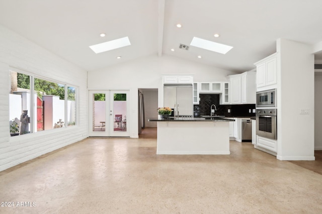 kitchen featuring white cabinetry, a center island with sink, backsplash, built in appliances, and beamed ceiling