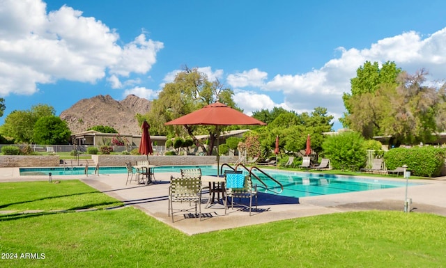 view of swimming pool with a mountain view, a yard, and a patio