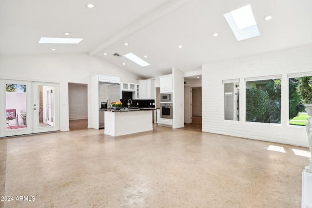 unfurnished living room featuring sink, beam ceiling, french doors, and high vaulted ceiling