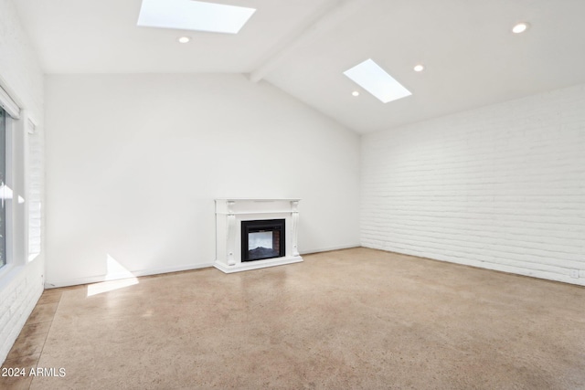 unfurnished living room with lofted ceiling with skylight and brick wall