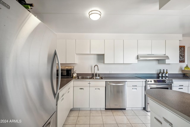 kitchen with white cabinets, appliances with stainless steel finishes, sink, and light tile patterned flooring