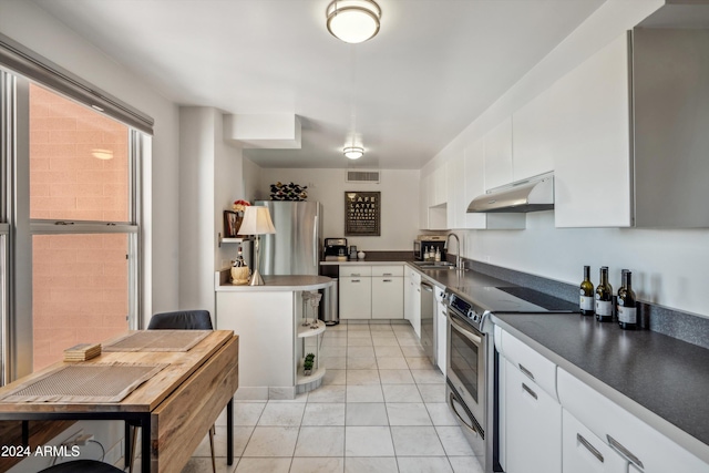 kitchen featuring sink, white cabinets, light tile patterned floors, and appliances with stainless steel finishes