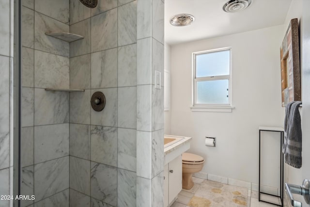 bathroom featuring toilet, vanity, and tiled shower