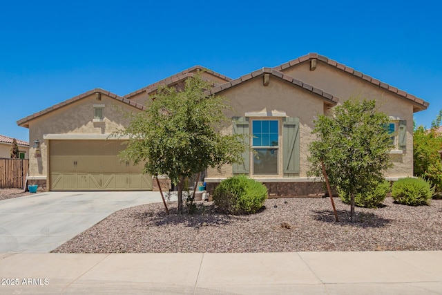 18474 W College Dr, Goodyear, AZ 85395 - mediterranean / spanish-style home featuring an attached garage, concrete driveway, stucco siding, and a tiled roof