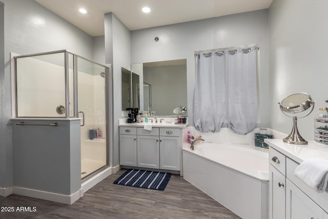 18474 W College Dr, Goodyear, AZ 85395 - bathroom featuring a stall shower, a garden tub, wood finished floors, vanity, and recessed lighting