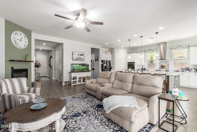 18474 W College Dr, Goodyear, AZ 85395 - living room featuring light wood-type flooring, ceiling fan, recessed lighting, and a glass covered fireplace
