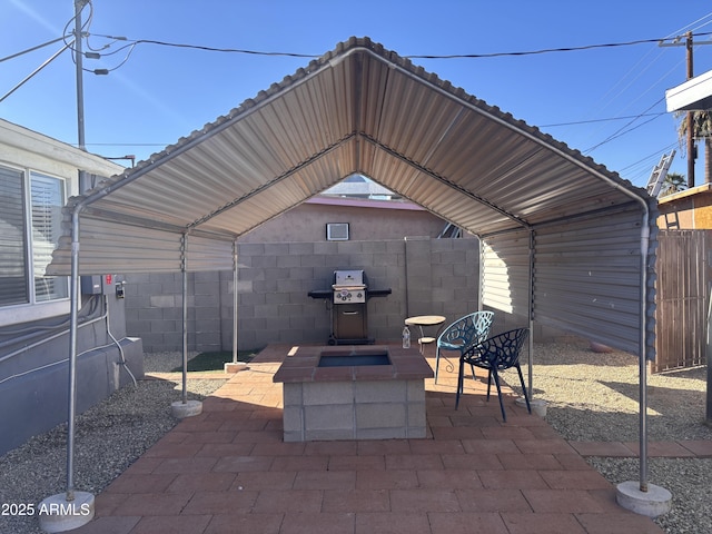 view of patio featuring a carport, grilling area, and a fire pit