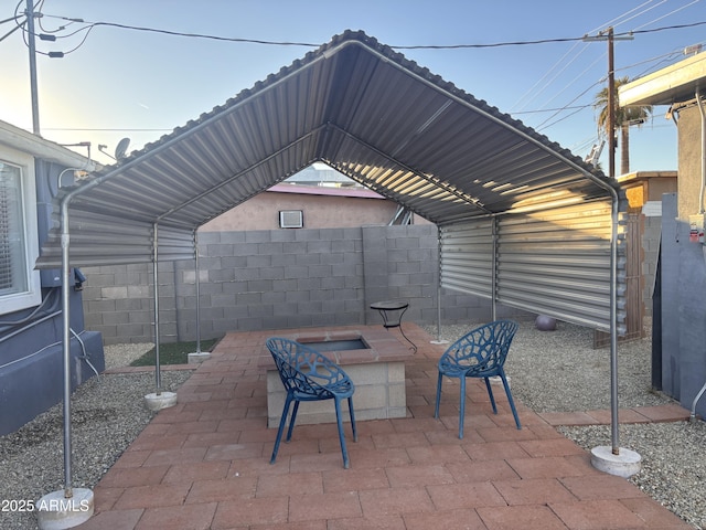 view of patio / terrace featuring a carport and an outdoor fire pit