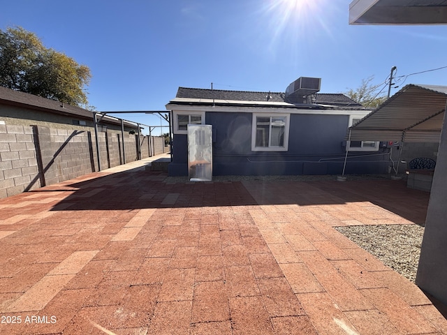 rear view of property with central AC