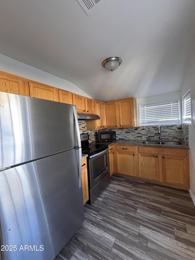 kitchen featuring lofted ceiling, sink, appliances with stainless steel finishes, dark hardwood / wood-style floors, and decorative backsplash