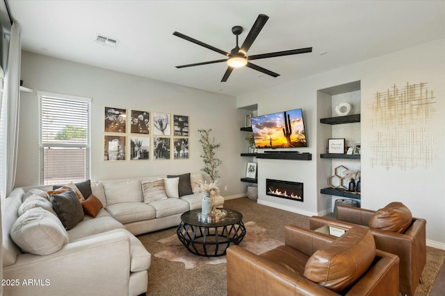 carpeted living room featuring built in features and ceiling fan