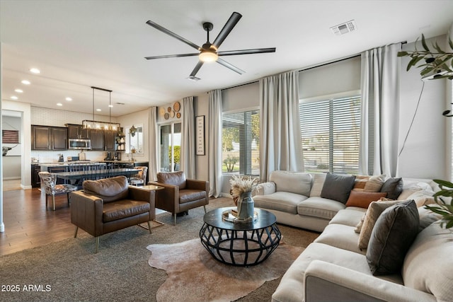 living room with dark hardwood / wood-style floors and ceiling fan