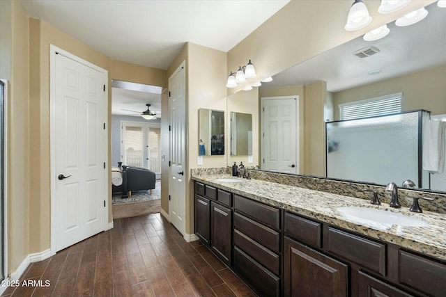 bathroom featuring hardwood / wood-style flooring, vanity, a shower with door, and ceiling fan