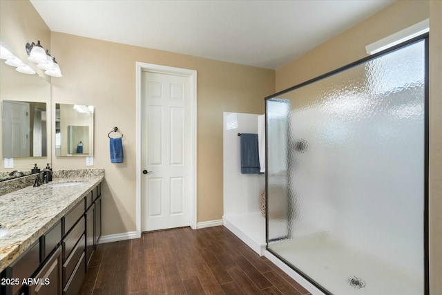 bathroom with an enclosed shower, vanity, and wood-type flooring