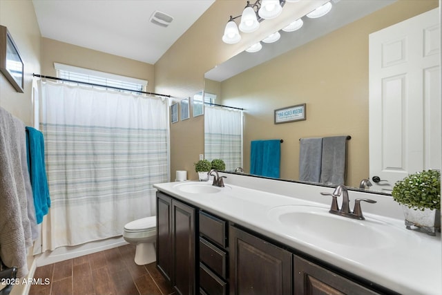 full bathroom with shower / tub combo with curtain, vanity, toilet, and wood-type flooring