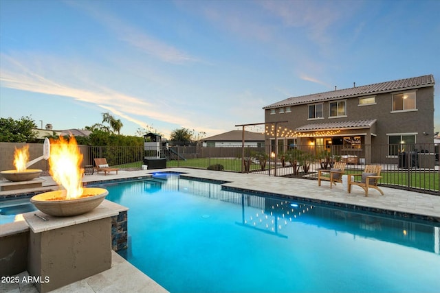 view of swimming pool featuring a patio and a fire pit