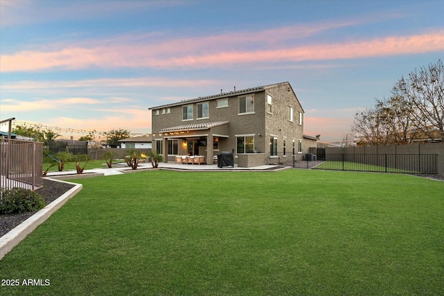 back house at dusk with a yard, a pergola, and a patio