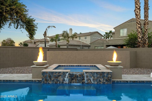 view of pool with an in ground hot tub and a fire pit