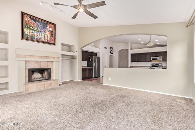 10001 W Potter Dr, Peoria, AZ 85382 - unfurnished living room featuring built in shelves, ceiling fan, carpet, a tiled fireplace, and baseboards