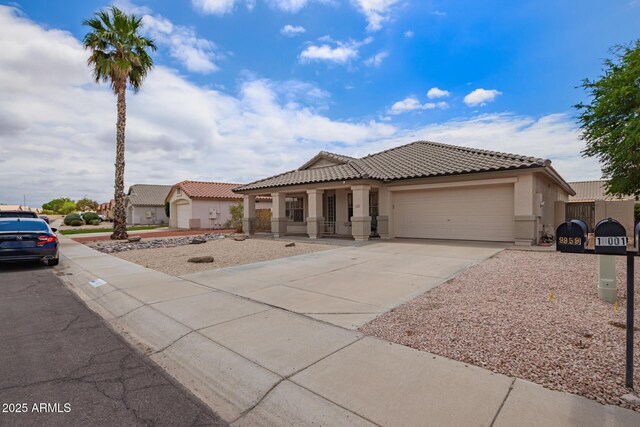 10001 W Potter Dr, Peoria, AZ 85382 - mediterranean / spanish house with an attached garage, stucco siding, driveway, a porch, and a tile roof