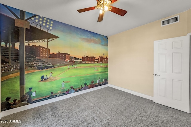 carpeted empty room with a ceiling fan and baseboards