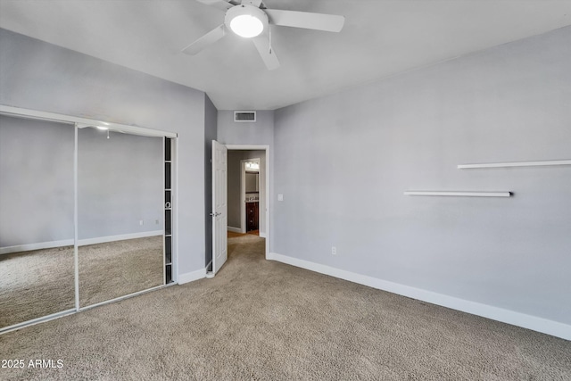 unfurnished bedroom with carpet flooring, a closet, baseboards, and ceiling fan