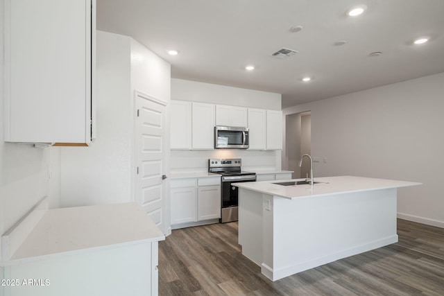 kitchen featuring sink, stainless steel appliances, an island with sink, and white cabinets