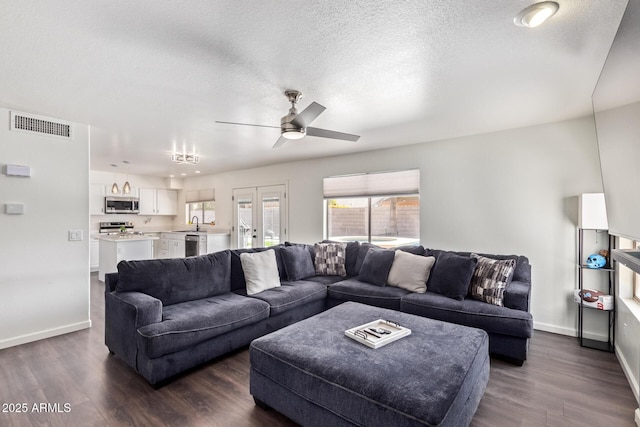 living room with dark hardwood / wood-style floors, sink, ceiling fan, a textured ceiling, and french doors