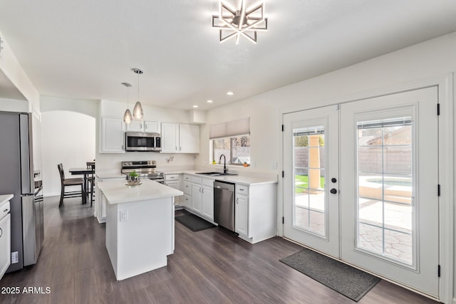 kitchen with sink, white cabinetry, a center island, pendant lighting, and stainless steel appliances