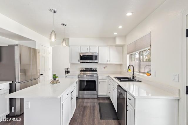 kitchen featuring sink, a center island, appliances with stainless steel finishes, pendant lighting, and white cabinets