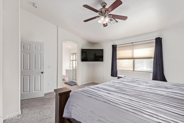 carpeted bedroom with ceiling fan, lofted ceiling, connected bathroom, and multiple windows