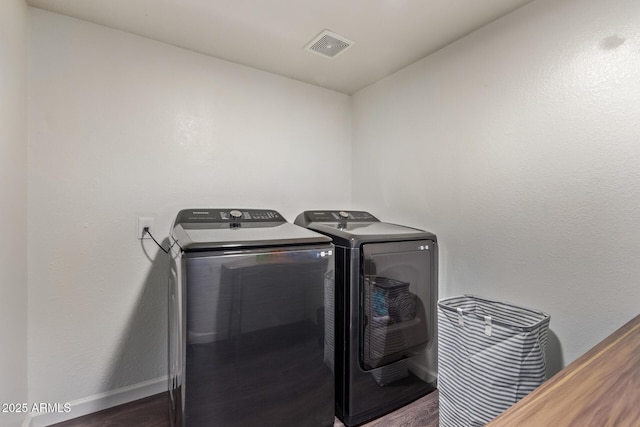 washroom featuring dark wood-type flooring and independent washer and dryer