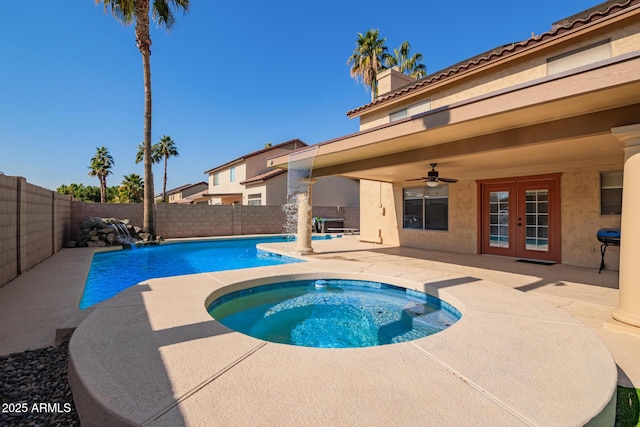 view of swimming pool featuring ceiling fan, a patio, french doors, pool water feature, and an in ground hot tub