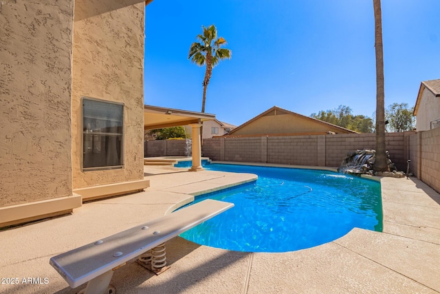 view of pool featuring a diving board, pool water feature, and a patio area