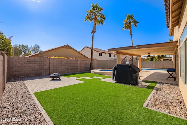 view of yard featuring a fenced in pool, a patio area, ceiling fan, and an outdoor fire pit