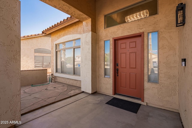 view of exterior entry featuring a patio