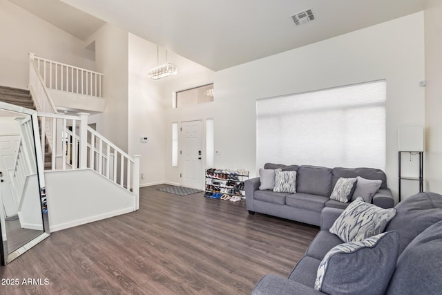 living room with dark wood-type flooring and high vaulted ceiling