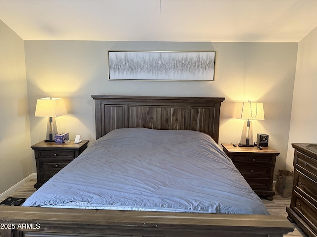bedroom featuring wood finished floors and baseboards