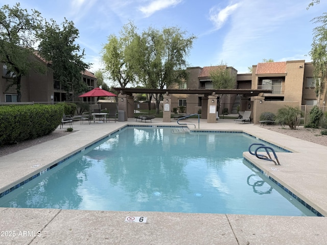 community pool featuring a patio and fence