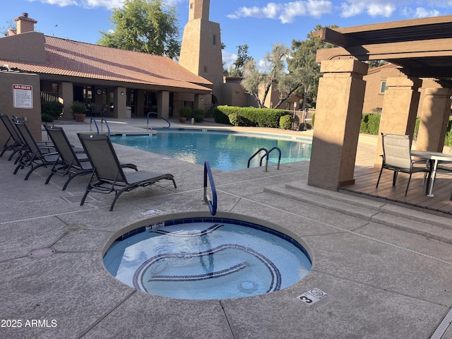 community pool featuring a patio and a hot tub