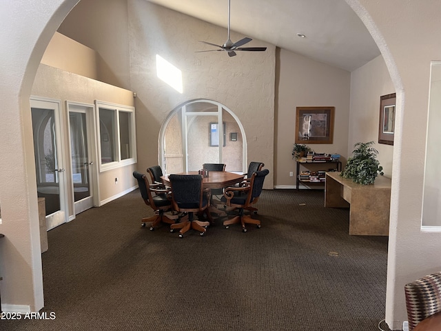 carpeted dining space featuring baseboards, french doors, a ceiling fan, high vaulted ceiling, and arched walkways