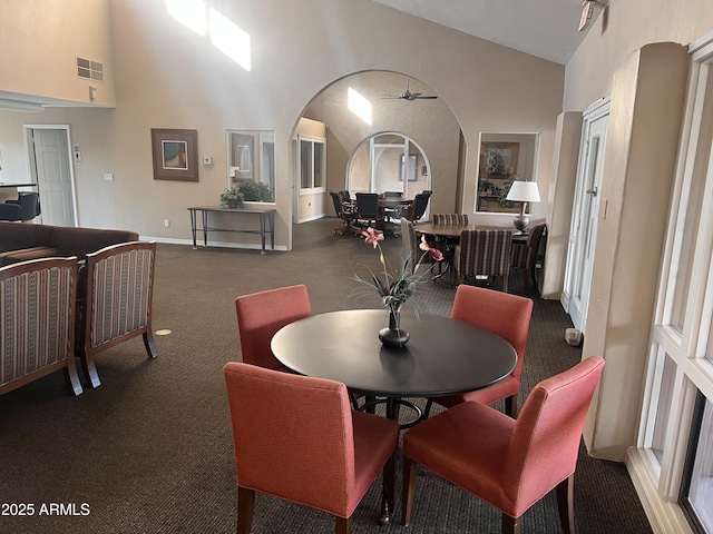 dining space featuring high vaulted ceiling, arched walkways, carpet, and visible vents