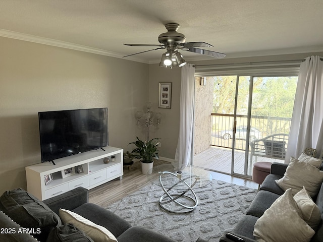 living area with ornamental molding, baseboards, a ceiling fan, and wood finished floors